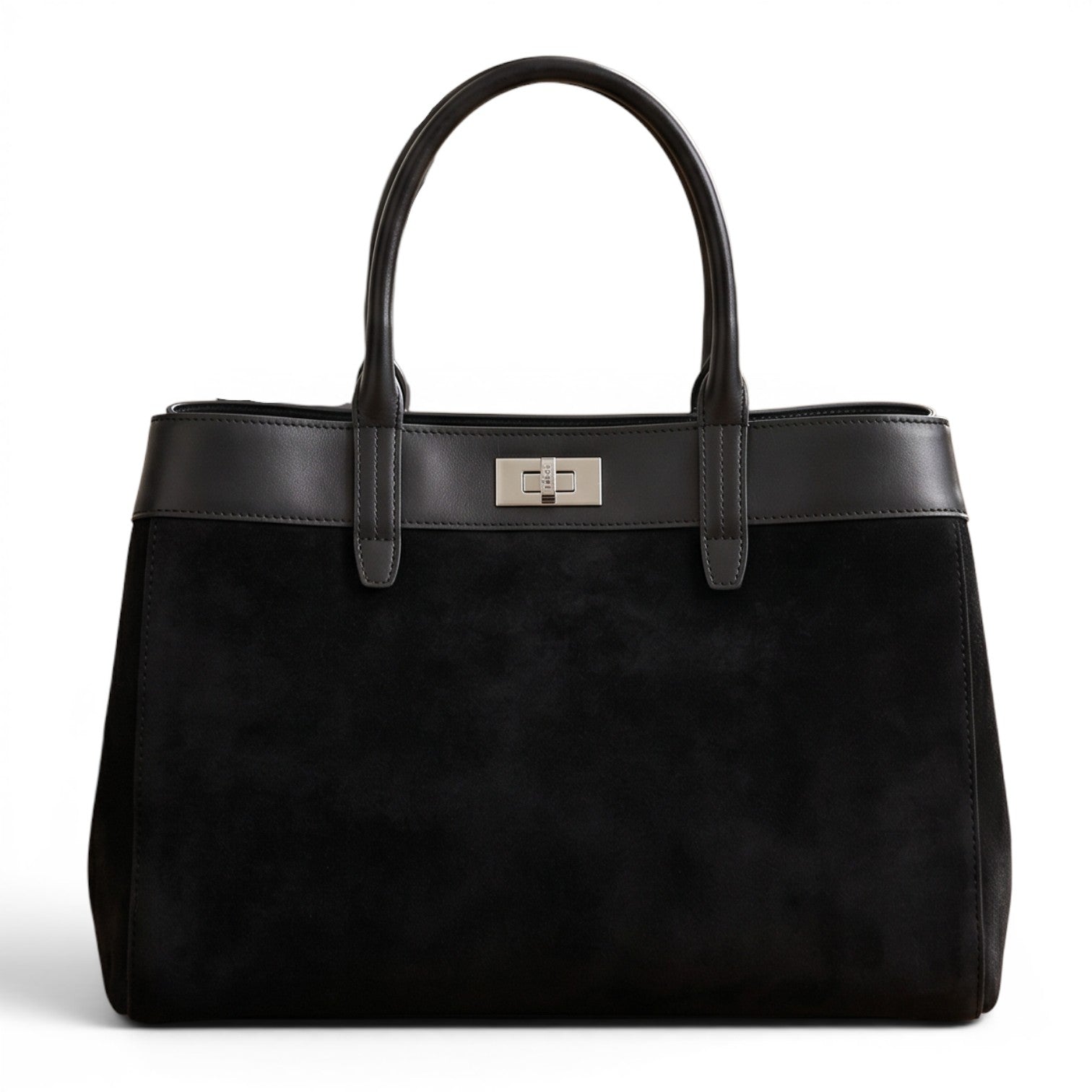 Sac grand cabas noir en cuir suédé et cuir lisse avec fermoir métallique, posé sur un parquet dans un intérieur chic.