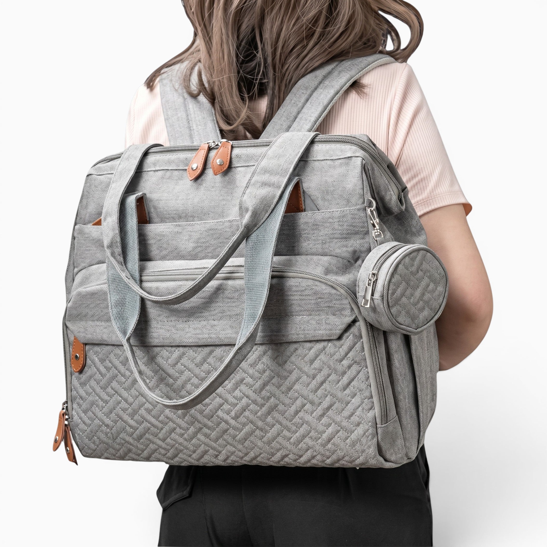 Sac sac à langer gris multifonction avec pochette tétine, utilisable en sac à dos, sac à main ou bandoulière.