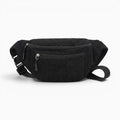 Sac banane noir en velours côtelé avec fermeture éclair et sangle réglable, style décontracté et pratique.