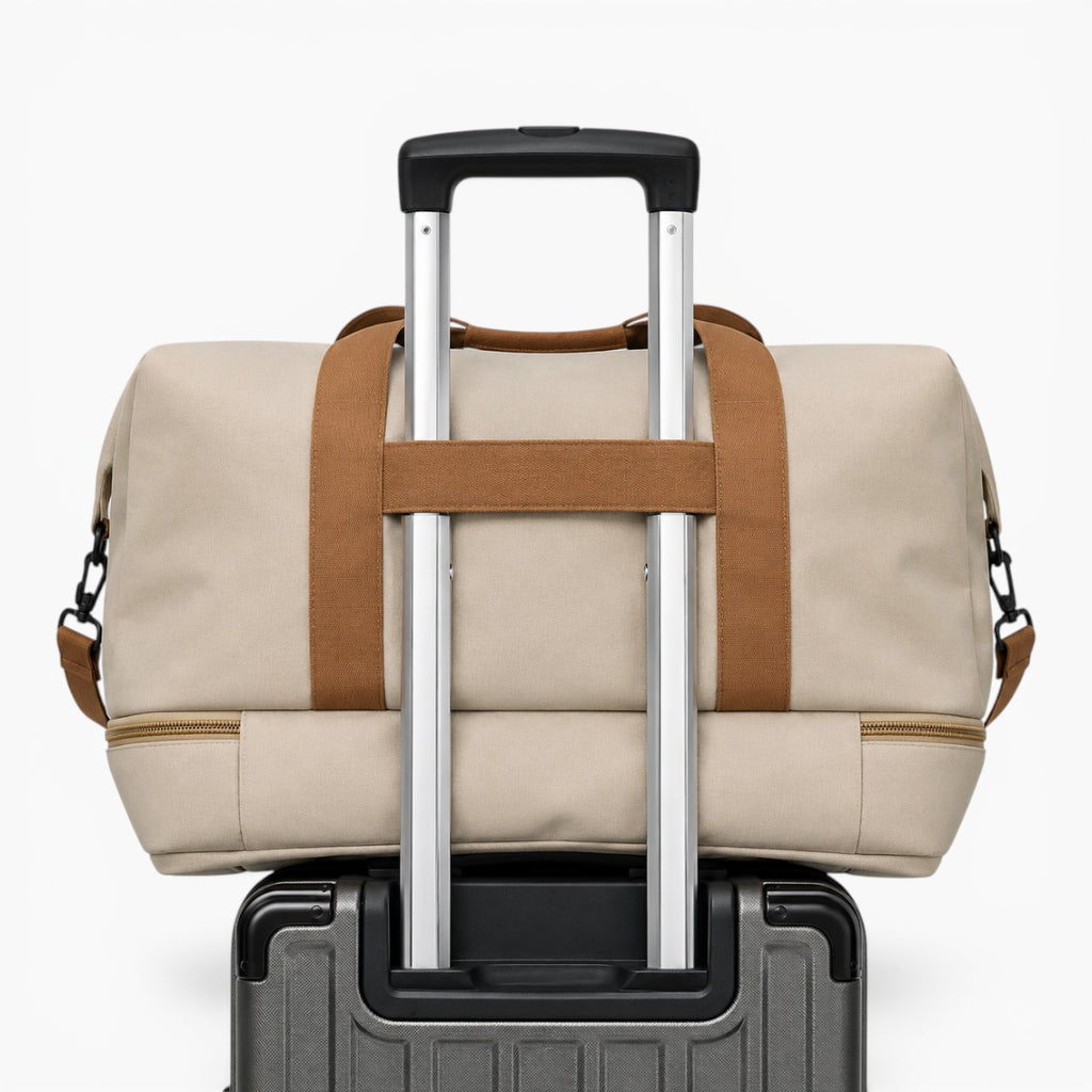 Sac de voyage beige Sac avec compartiment chaussures, fixé sur une valise à roulettes pour un transport facile.