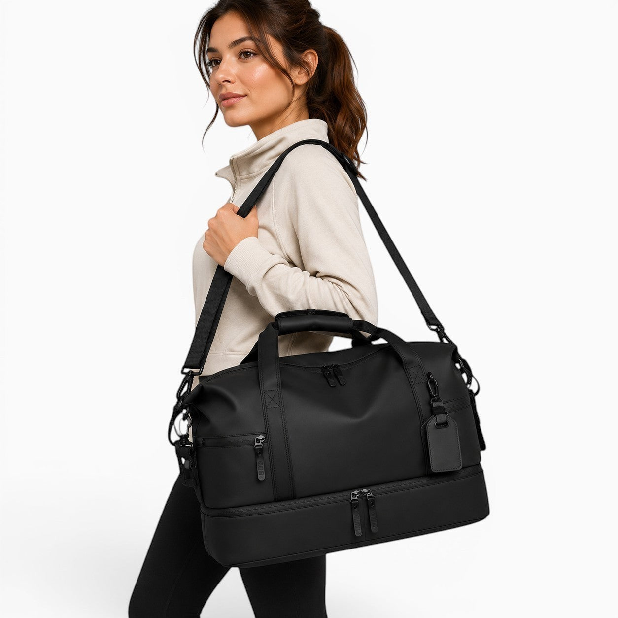 Sac sac de sport noir en PU imperméable avec compartiment inférieur zippé, porté par une femme.